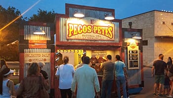 Pecos Pete's Soda stand at a nighttime festival in texas.